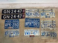 All fifteen license plates mounted on wall, various numbers and decals visible