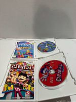 Open cases showing cover inserts and matching game discs for Carnival Games and Tetris Party Deluxe on Wii platform
