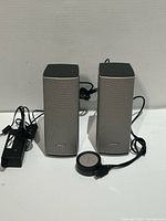 Front view of both speakers, control pod, power adapter and cables