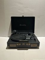 Open Crosley suitcase turntable showing platter, tonearm, controls and power cord