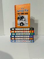 Stack of seven Diary of a Wimpy Kid hardcovers numbered 9-15