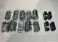 Top view showing ten steel electrical boxes and four black breakers