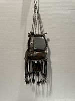 Full view of hanging plated silver wind-chime candle holder with fork-tine chimes