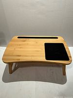 Top view of bamboo laptop stand showing mousepad and slot