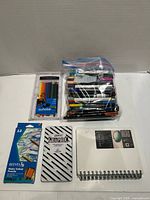 All items laid out: marker bag, three boxed pencil sets, two sketchbooks