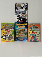 Front covers of the four Pokémon reference books standing upright