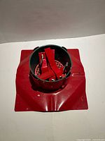 Red metal square-base Christmas tree stand with green collar and securing wedges