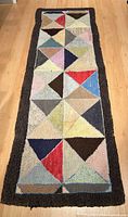 Full view of rectangular multicolour geometric patterned rug runner with dark border