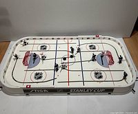 Top view of complete Stiga Stanley Cup table hockey game showing rink, players, goals, and pucks