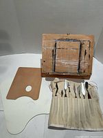 Easel open with palettes and palette knives in canvas roll
