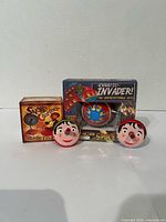 All four tin toys, two loose Pinocchio tops, boxed Snake Charmer top, boxed Erratic Invader UFO