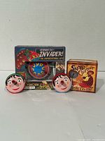 Boxed Erratic Invader UFO toy, boxed Snake Charmer spinning top, two loose Pinocchio spinning tops
