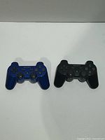 Front view showing both Sony DualShock 3 controllers, one blue and one black