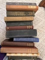 Side view of stacked hardcover books showing quantity and varied bindings