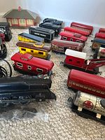 close view of various tin litho cars and locomotive on carpet