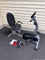 Full view of assembled MaxKare recumbent exercise bike with seat, console, and accessories on ground