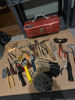 Overview of all tools spread on cardboard with red toolbox