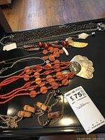 Overview of all necklaces laid on black surface