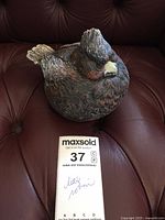 Front view of concrete bird figurine displaying crest, beak and overall paint finish