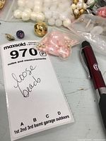 Overall lot showing assorted beads and jewelry parts with MaxSold tag