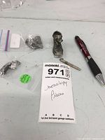 Overall view of all pieces on table including bagged tokens, loose token, and miniature tool