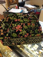 Front and side view of quilted floral bowler bag displaying exterior pattern, handles, and overall condition