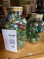 Two jars of mixed marbles with MaxSold lot card visible