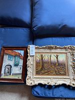 Both framed oil paintings side by side on cushions
