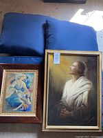 Two framed religious paintings side by side