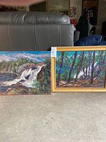 Both paintings side by side on floor, showing size comparison and frames