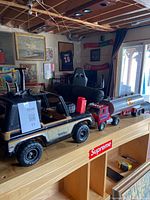 Both toys on shelf: Tonka jeep foreground, Ertl tanker truck behind