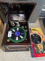 Gramophone open with record on platter and additional records to right