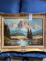 Full view of framed oil painting showing landscape scene and frame