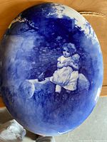 Front of blue and white Royal Doulton oval wall plaque