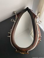 Full view of horse collar mirror showing leather and cast metal frame