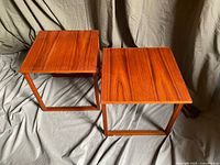 two square teak nesting tables side by side front view
