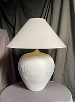 Full view of lamp with shade on neutral backdrop