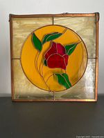 Front view of stained glass panel showing rose design and copper frame