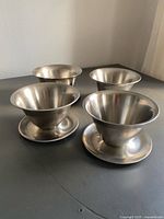 four stainless steel bowls, angled view
