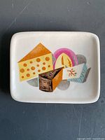front view of rectangular ceramic plate with colorful cheese illustration