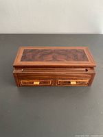 Front view showing burl veneer lid, drawers, brass pulls