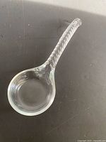 top view of clear glass serving spoon showing bowl and handle detail