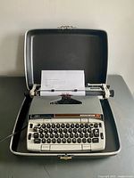 Typewriter inside open carrying case showing overall condition