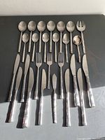 All 26 pieces laid out on dark surface