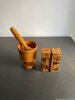 Mortar with pestle inserted alongside olive wood inlay salt and pepper shakers