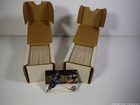 Two white corrugated storage boxes filled with trading cards