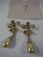 Full view of both earrings showing design, rhinestones, faux pearls