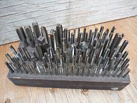 Front view of wooden block densely filled with metal taps