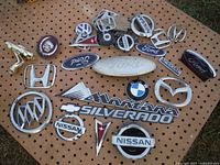 Overall view of assorted vehicle emblems on pegboard