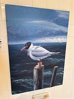 Full view of unframed seabird print on tiled wall